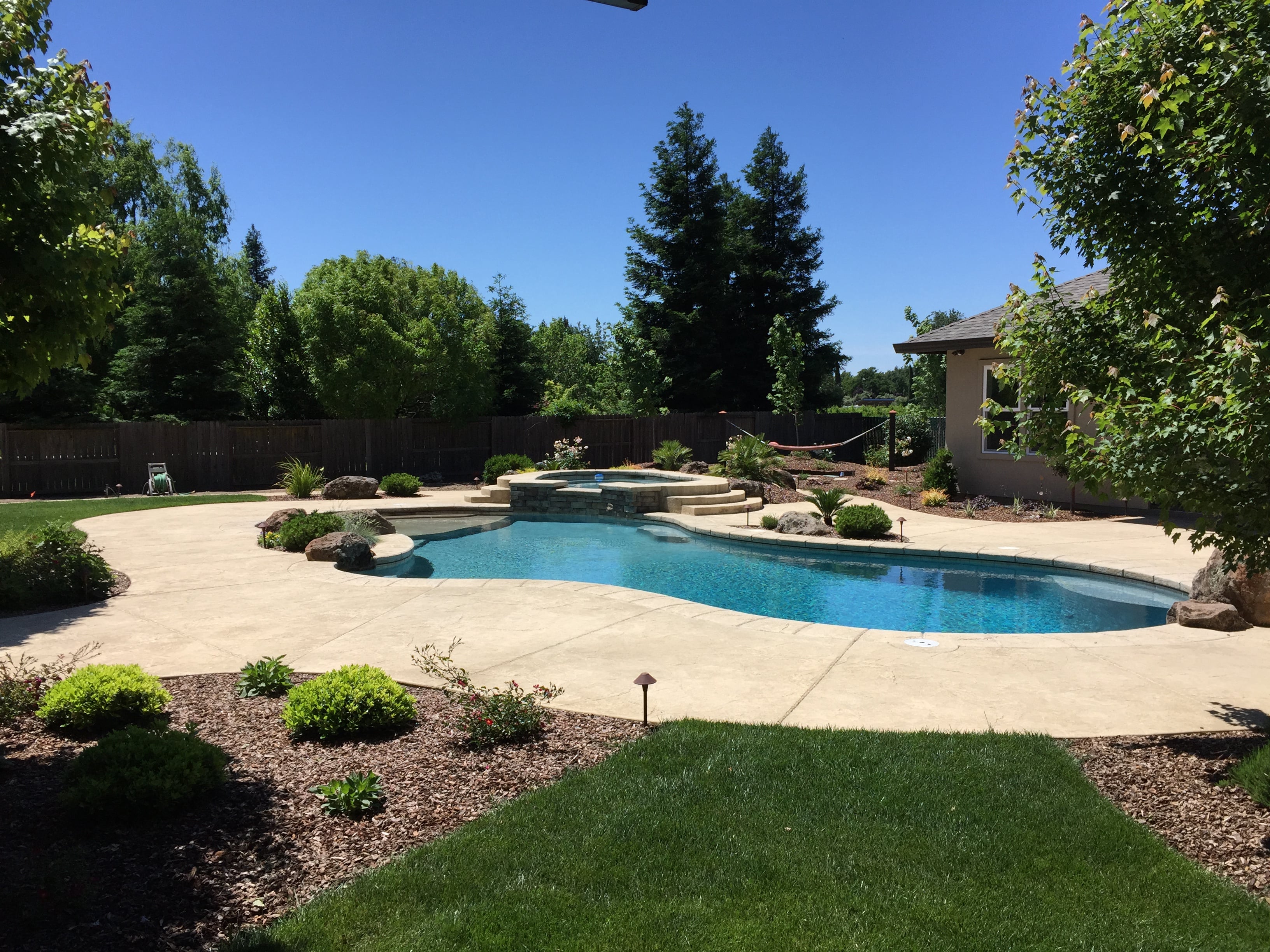 pool surrounded by cement in front of a house